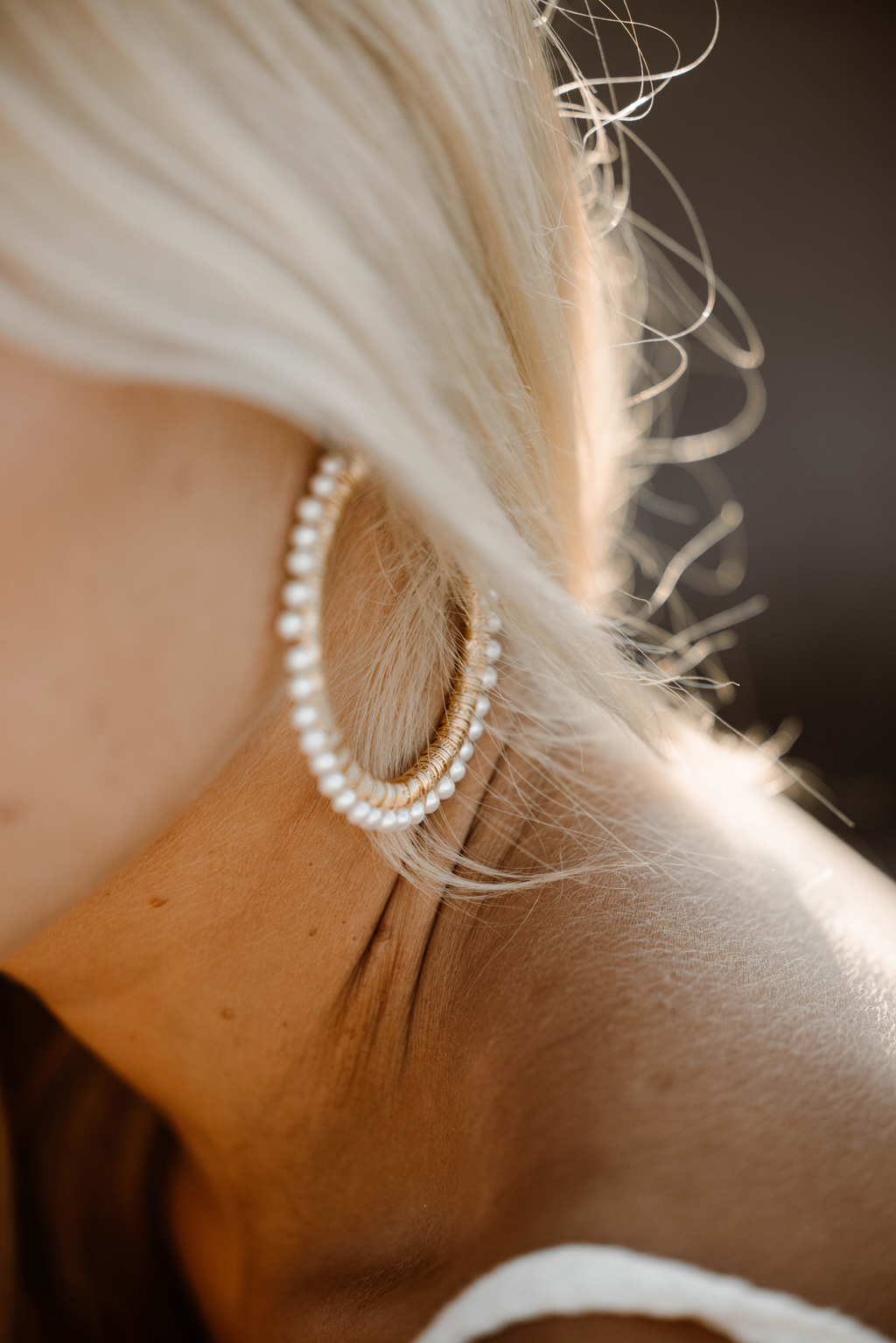 Close-up of a person wearing a beaded earring with a blurred background