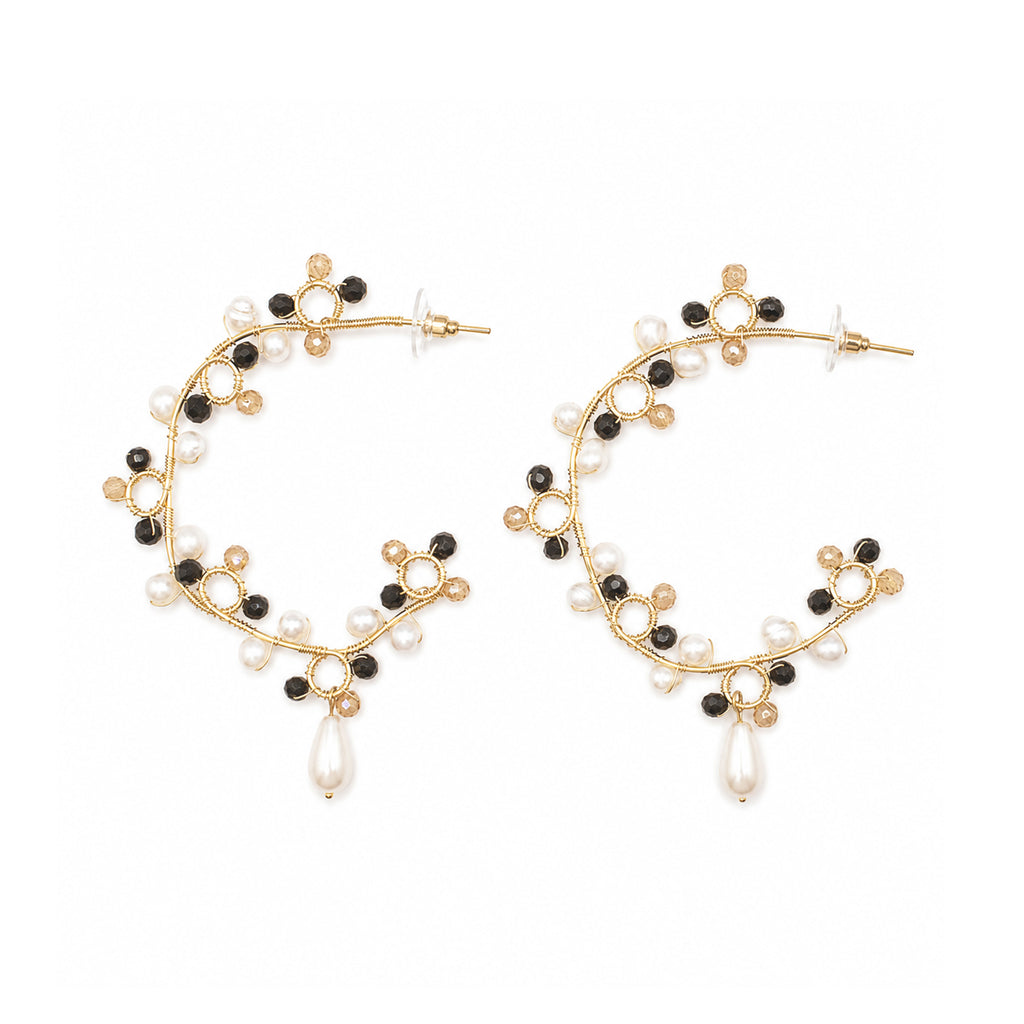 Gold hoop earrings with black and white bead accents on a white background