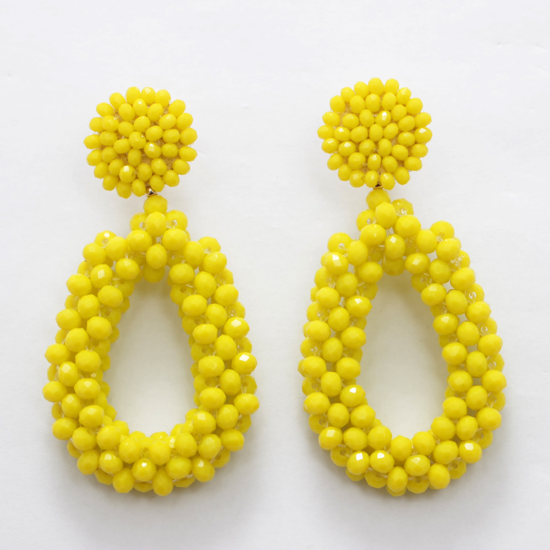Pair of yellow beaded earrings on a white background